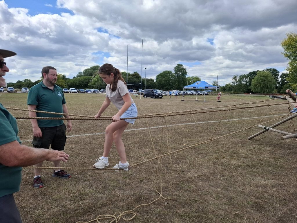 Local Scout groups provided rustic sports events such as this rope bridge, which a girl is crossing
